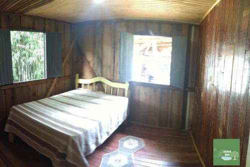 Habitación pequeña con cama y ventana en Refugio Verde Zen, en Dois Vizinhos