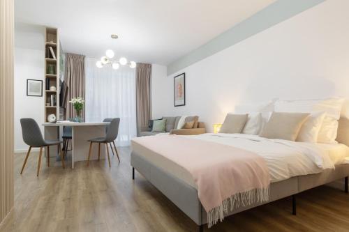a bedroom with a large bed and a table and chairs at Cozy Garden Studio - Free Parking - Wellness SPA in Sinaia