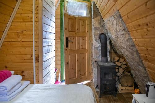 a bedroom with a wood stove in a cabin at STD SRCE KAMENE GORE in Kamena Gora