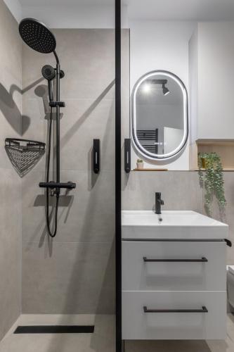 a bathroom with a sink and a shower with a mirror at Cozy Garden Studio - Free Parking - Wellness SPA in Sinaia