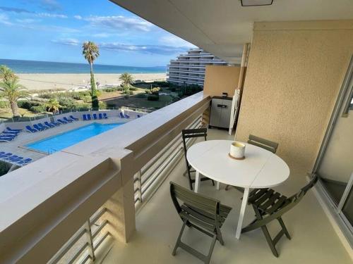 d'un balcon avec une table et des chaises et une vue sur la plage. dans l'établissement Bel appartement vue mer accès direct plage, à Canet