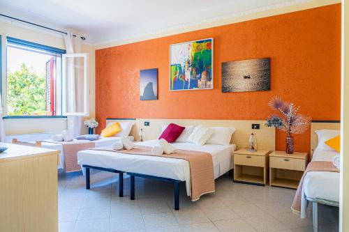 1 dormitorio con 2 camas y paredes de color naranja en Hotel Le Macine, en Santa Cesarea Terme