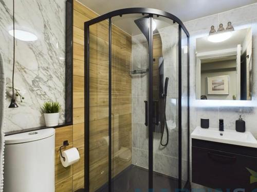 een badkamer met een douche, een toilet en een wastafel bij Spacious open planned 1 bedroom apartment in Burgess Hill