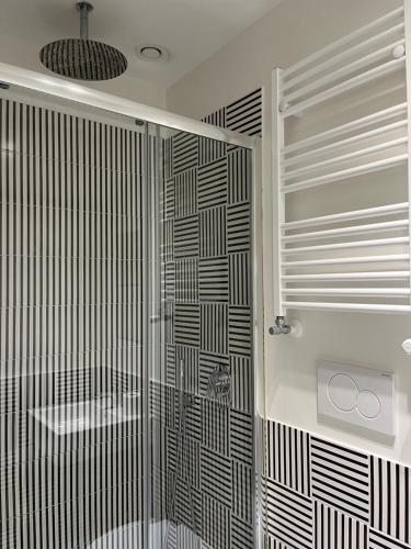 a bathroom with a shower with black and white tiles at LOFT 13 in Maiori