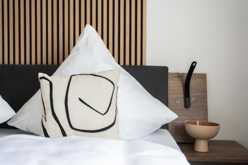 cuscino bianco e nero, posto sopra un letto di 1-4 Gäste Wohnung W-Lan, Netflix, Amazon, Parken, Arbeitsplatz, 24h Check in ,Vollausgestattet Küche, Handtücher Seife u,v,m für Geschäftsreisende, Paare, Familien , a Datteln