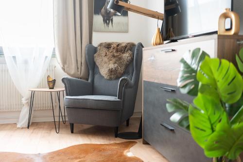 un soggiorno con una sedia e un tavolo di 1-4 Gäste Wohnung W-Lan, Netflix, Amazon, Parken, Arbeitsplatz, 24h Check in ,Vollausgestattet Küche, Handtücher Seife u,v,m für Geschäftsreisende, Paare, Familien , a Datteln
