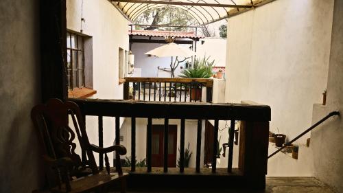 uma varanda de uma casa com uma cadeira e um guarda-chuva em Casa Gardenia Hotel em Tecozautla