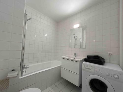 uma casa de banho branca com uma máquina de lavar roupa em Studio avec Balcon, belle vue em Courbevoie