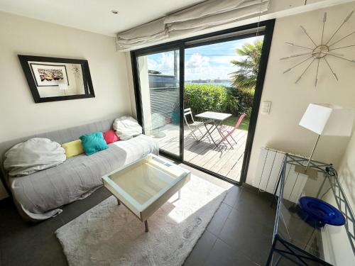 a living room with a couch and a glass table at Appartement T2 super cosy - Front de mer in Larmor-Plage