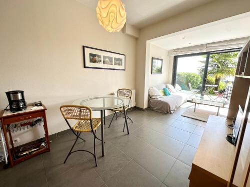 a living room with a table and chairs and a couch at Appartement T2 super cosy - Front de mer in Larmor-Plage