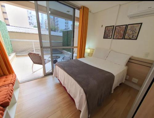 a bedroom with a large bed and a balcony at MENSAL Studio Prox Shopping Frei Caneca 103, 105, 203 in Sao Paulo