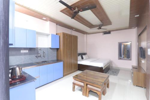 a kitchen with a table and a bed in a room at BK home stay in Transport Nagar