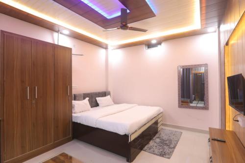 a bedroom with a bed and a cabinet and a television at BK home stay in Transport Nagar