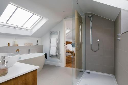 a bathroom with a shower and a sink at Luxury Devon Hayloft with panoramic Dartmoor views in Ilsington