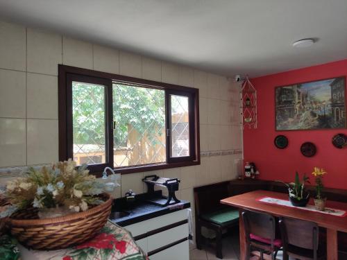 een keuken met een wastafel en een tafel met een mand bij Quarto Felicidade Cabeçudas in Itajaí