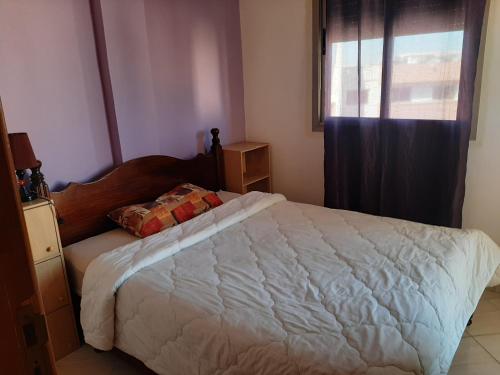 um quarto com uma grande cama branca e uma janela em Charmant appartement à louer à meknès em Meknès