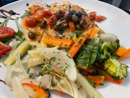 a white plate of food with vegetables on it at Hotel Ristorante della posta , cama in Cama