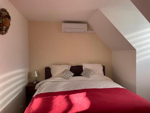 a bedroom with a bed with a red blanket at Chambre climatisée, entre Paris Disneyland, au coeur des Jeux Olympiques canoë-kayak, in Vaires-sur-Marne