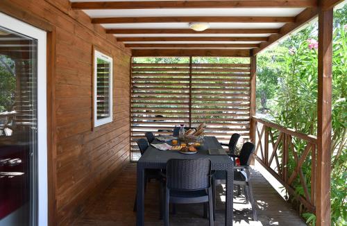 a patio with a table and chairs on a deck at Location du Ranch in Algajola