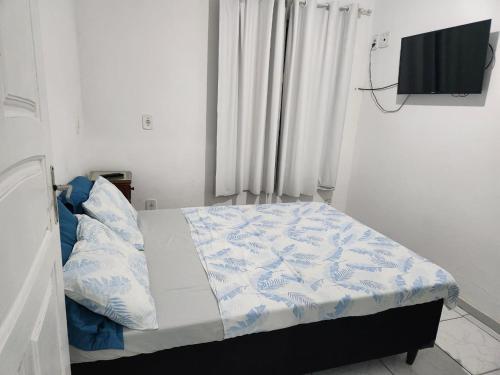 a bed in a room with a tv on the wall at Arraial Sobradinho in Arraial do Cabo