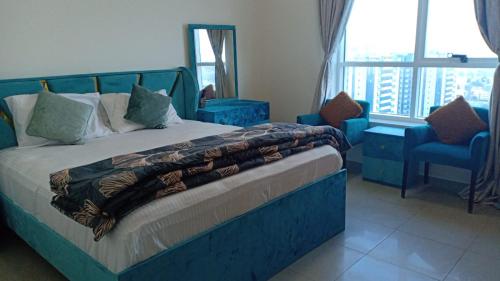 a bedroom with a blue bed with a chair and a window at 22 R3 Luxury Room in a 4-bedroom apartment with private washroom outside the room ### 22 R3 غرفة فاخرة في شقة 4 غرف نوم مع حمام خاص خارج الغرفة ### in Ajman 