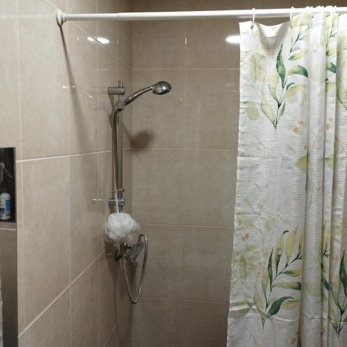 a shower with a shower curtain in a bathroom at Angel's home in Dublin