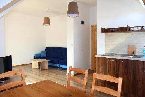 Una sala de estar con una mesa y un sofá azul. en Villa Elmar, en Kiten