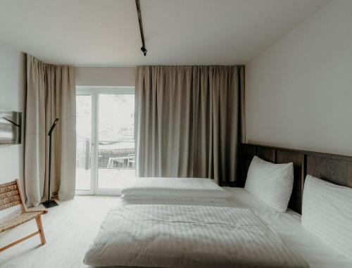 a bedroom with a bed and a window at kerii - adults boutique hotel in Saalbach Hinterglemm