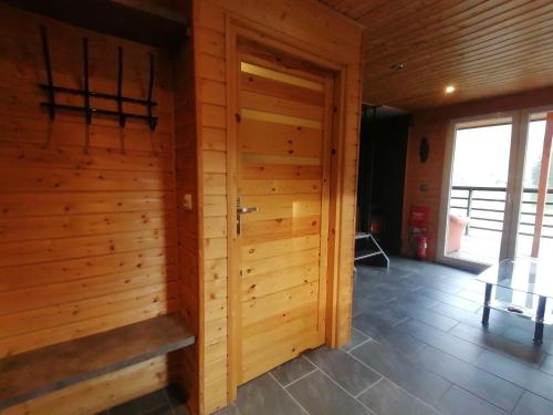 a room with a wooden wall with a door at Fala - Domki do wynajecia in Zagórze Śląskie
