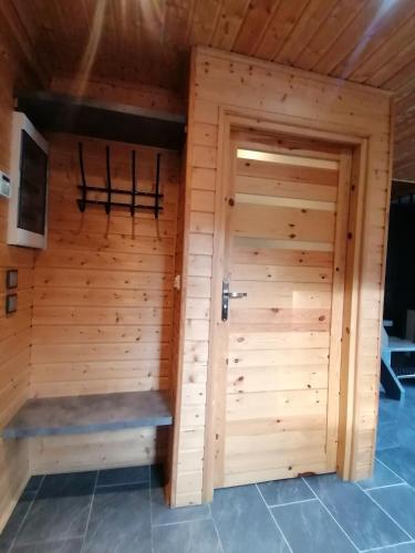 a wooden sauna with a large wooden door at Fala - Domki do wynajecia in Zagórze Śląskie