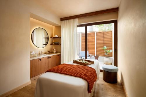 a bedroom with a bed and a sink and a mirror at Fairmont Mayakoba in Playa del Carmen