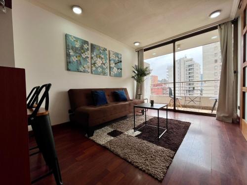 een woonkamer met een bank en een tafel bij Apartamentos City Centro Manuel Montt in Santiago