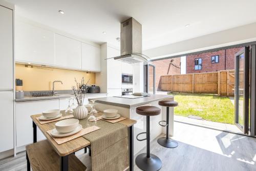 a kitchen with a table and a counter top at Rest&Recharge at Brookdale House (5 Bedrooms, 15mins to City Centre, Free Parking) in Manchester