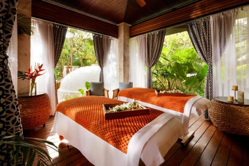 two beds in a room with a window at Fairmont Mayakoba in Playa del Carmen