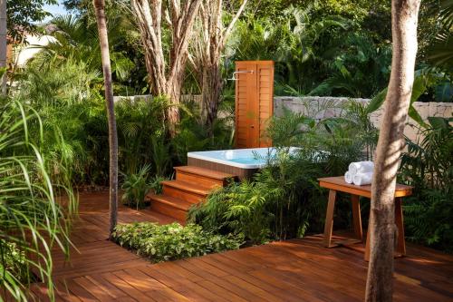 a wooden deck with a bench and a table at Fairmont Mayakoba in Playa del Carmen