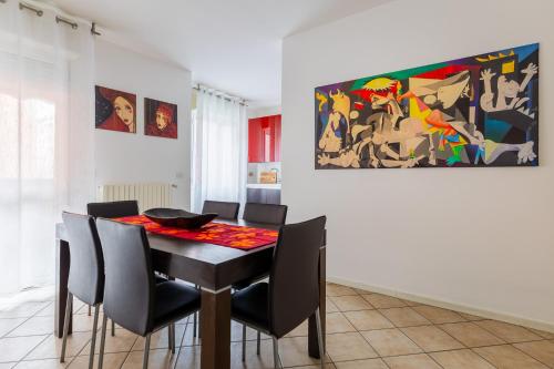 una sala da pranzo con tavolo, sedie e un quadro di Casa Pibe de oro Bologna Fiera a Bologna