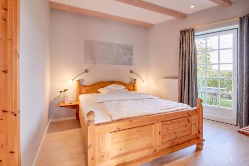 ein Schlafzimmer mit einem Holzbett und einem Fenster in der Unterkunft Hotel Am Steendamm in Oyten