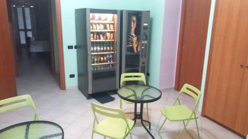 a room with a table and chairs and a refrigerator at Sunset Shores Oasis - Gulfview Haven Rooms with a View, strategic for Pompeii, Amalfi, Capri, and on the Road to Sorrento- progetto sociale Artigiani della preziosità in Castellammare di Stabia