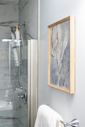 a bathroom with a shower and a picture on the wall at Charming Indianapolis Home~5 Min to Lucas Oil in Indianapolis