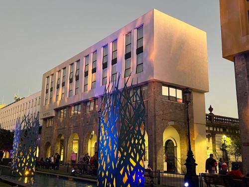 a building with a painting on the side of it at Six Hotel Guadalajara Degollado in Guadalajara