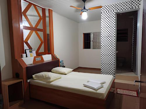 ein kleines Schlafzimmer mit einem Bett und einem Spiegel in der Unterkunft Hotel Pinheiros in São Paulo