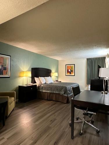 a hotel room with a bed and a desk at Days Inn by Wyndham Southern Hills/ORU in Tulsa