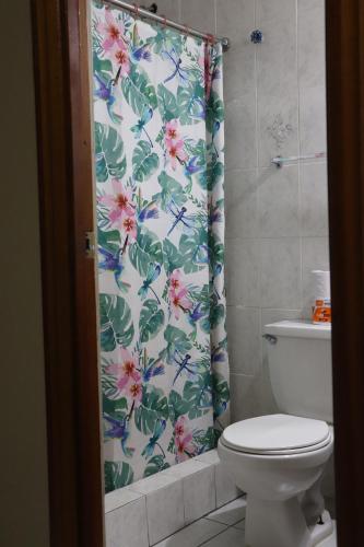 a bathroom with a shower curtain with a toilet at Hotel Toledo in David