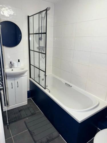 a white bathroom with a tub and a sink at Modern 2 Bed Apartment - Blue Madison in Aldershot