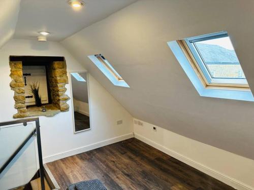 an attic room with a window and a stone wall at Little House Annexe in Shotteswell