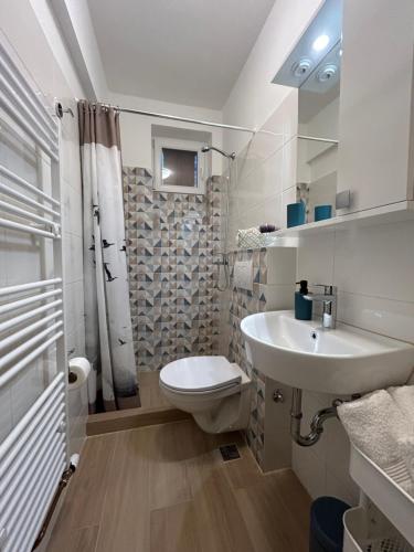 een witte badkamer met een toilet en een wastafel bij Holiday home Mandi in Vrbanj