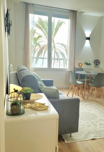 un salon avec un canapé bleu et une table dans l'établissement Studio face à la Méditerranée, à Cagnes-sur-Mer