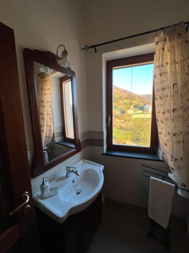 baño con lavabo y ventana en Á Ćà de Matilde en Ranzo-Borgo