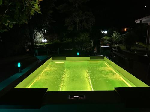 a large pool with green water at night at Il Sogno delle Rondini in Palidoro