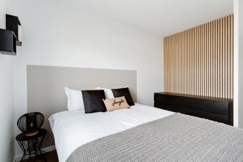 une chambre avec un grand lit avec des draps blancs dans l'établissement Élégance - DisneyLand Paris - Vallée Village - 7 à 9 personnes, à Serris